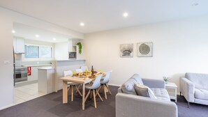 A modern apartment with a dining area, kitchen, and living space.