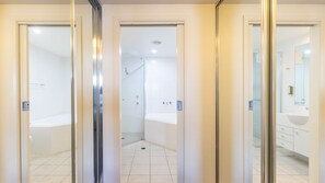 A modern bathroom with a shower, bathtub, and a sink.