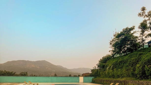 Une piscine avec des chaises longues et une vue sur les montagnes.