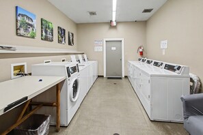 A laundry room with multiple washing machines, a drying rack, and a fire extinguisher. - Free Ticket to Dollywood, Anakeesta, and Other Area Attractions! (Gatlinburg)