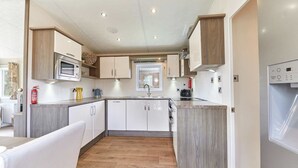 Una cucina moderna con mobili bianchi, un forno a microonde e un forno integrato.