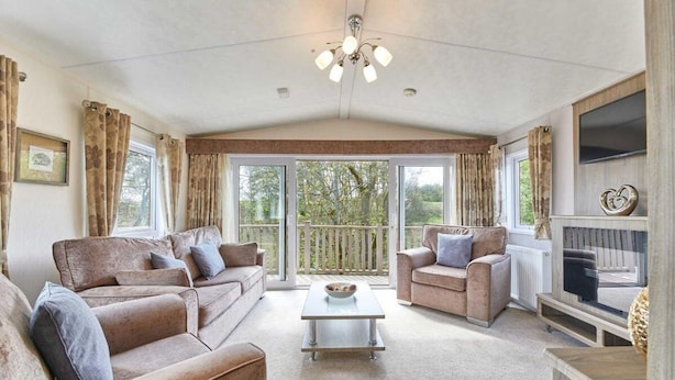 A spacious living room with two sofas, a coffee table, and a TV. - Host Stay Yolo Lodge (Morpeth)