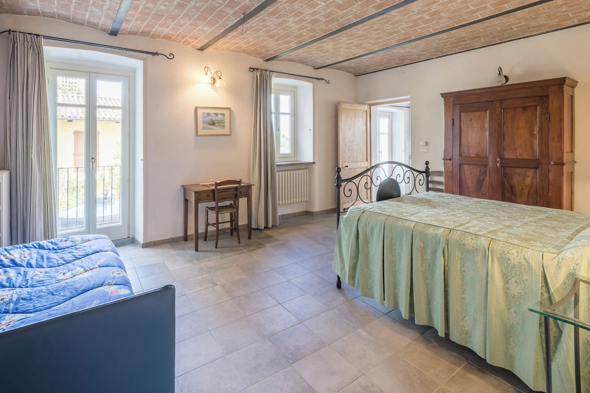 Une chambre à coucher avec un lit, une chaise, un bureau et une armoire.