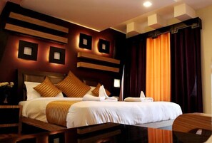 A hotel room with a large bed, dark curtains, and modern wall decor. - Hotel Ladakh Marvel Leh (Leh)