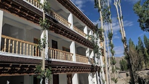 A two-story building with balconies and a garden area. - Hotel Ladakh Marvel Leh (Leh)