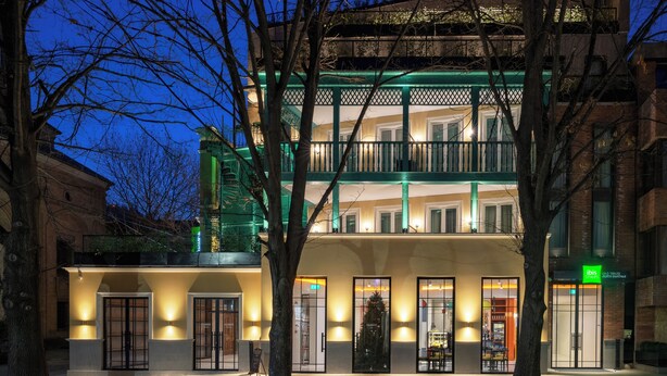 A multi-story building with a green balcony, a visible entrance, and a sign for 'Ibis' hotel. - Ibis Styles Old Tbilisi (Tbilisi)