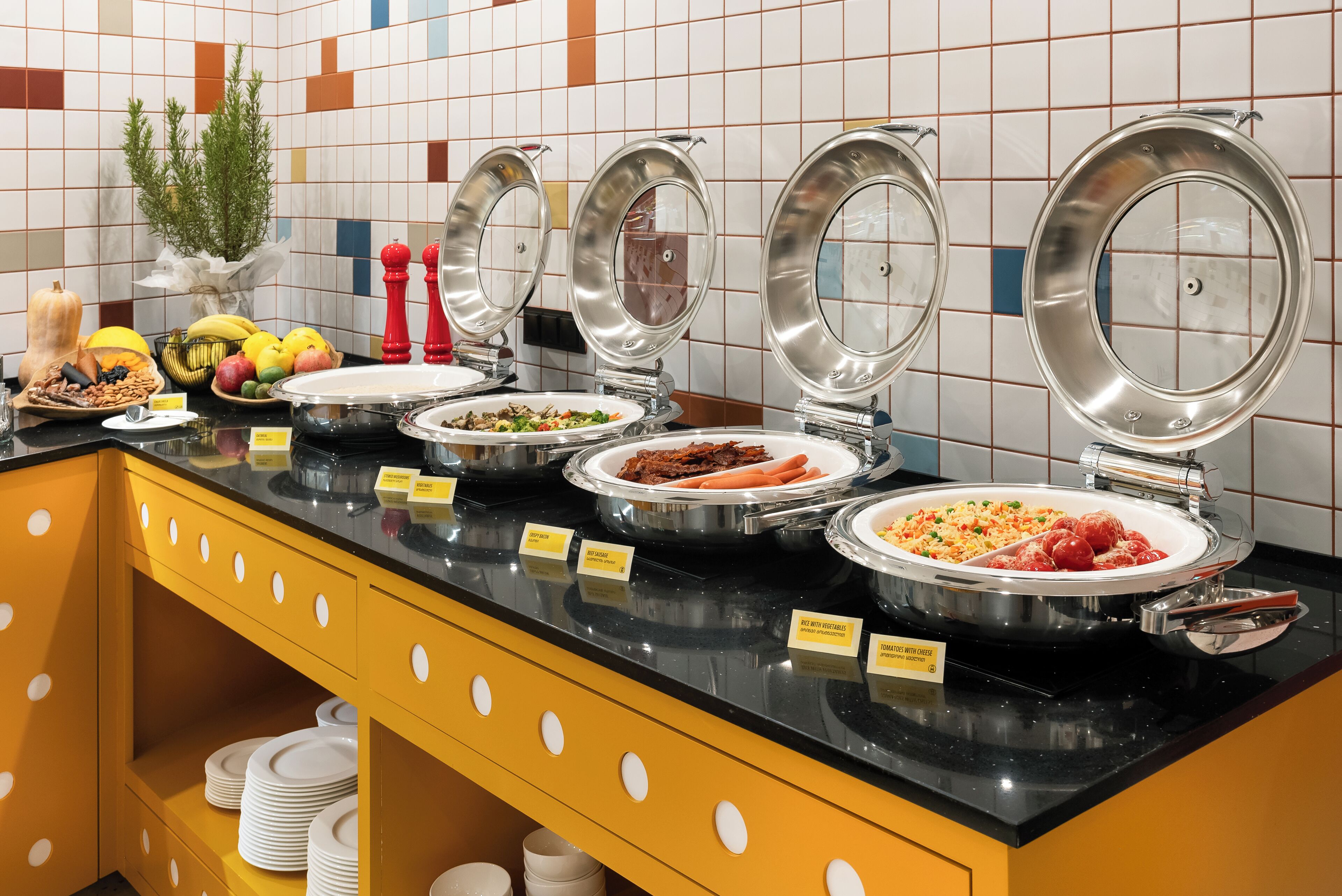 A buffet setup with various food items and labeled serving dishes.