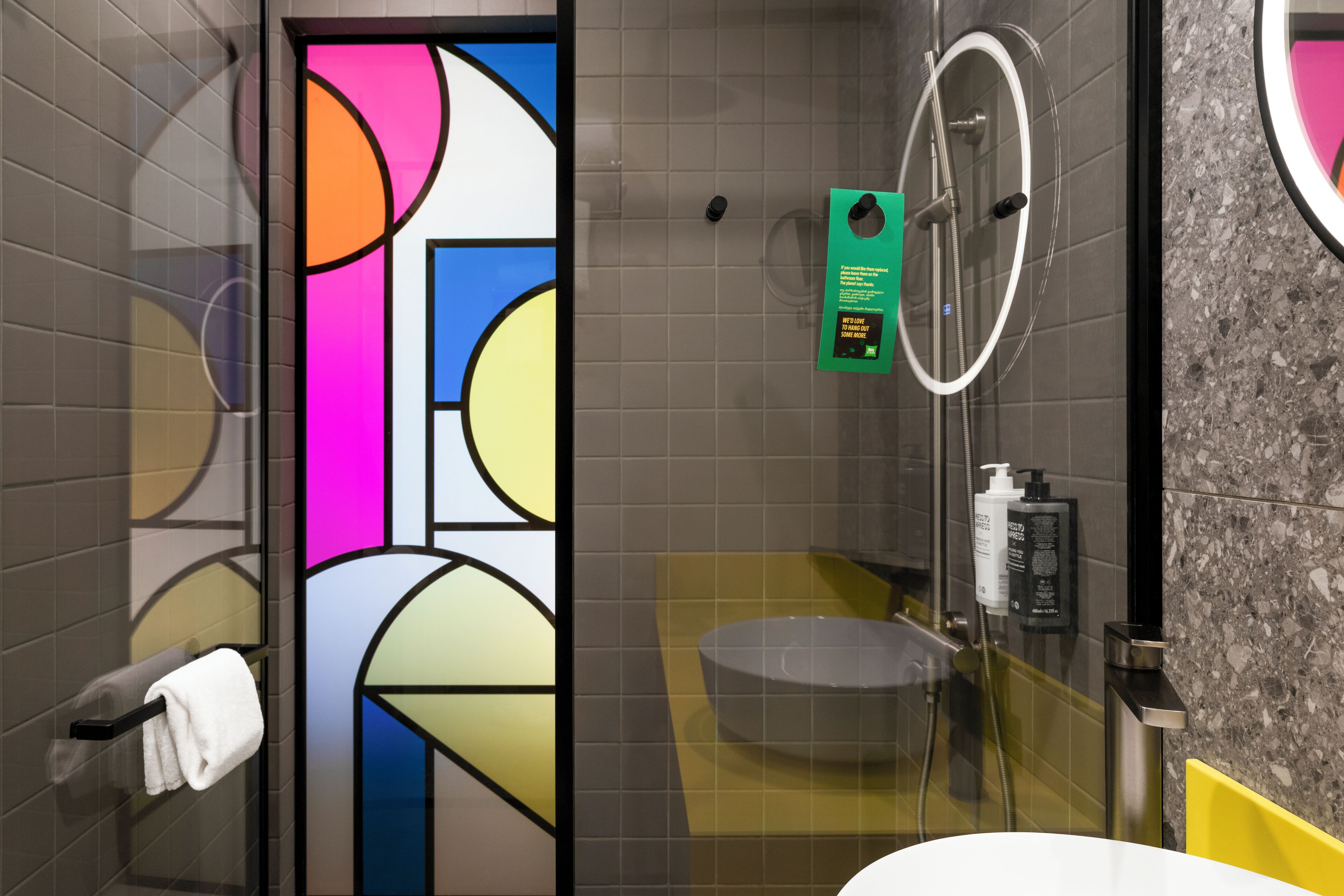 Ein modernes Badezimmer mit Glastrennwand, Waschbecken, Toilette und Duschbereich.