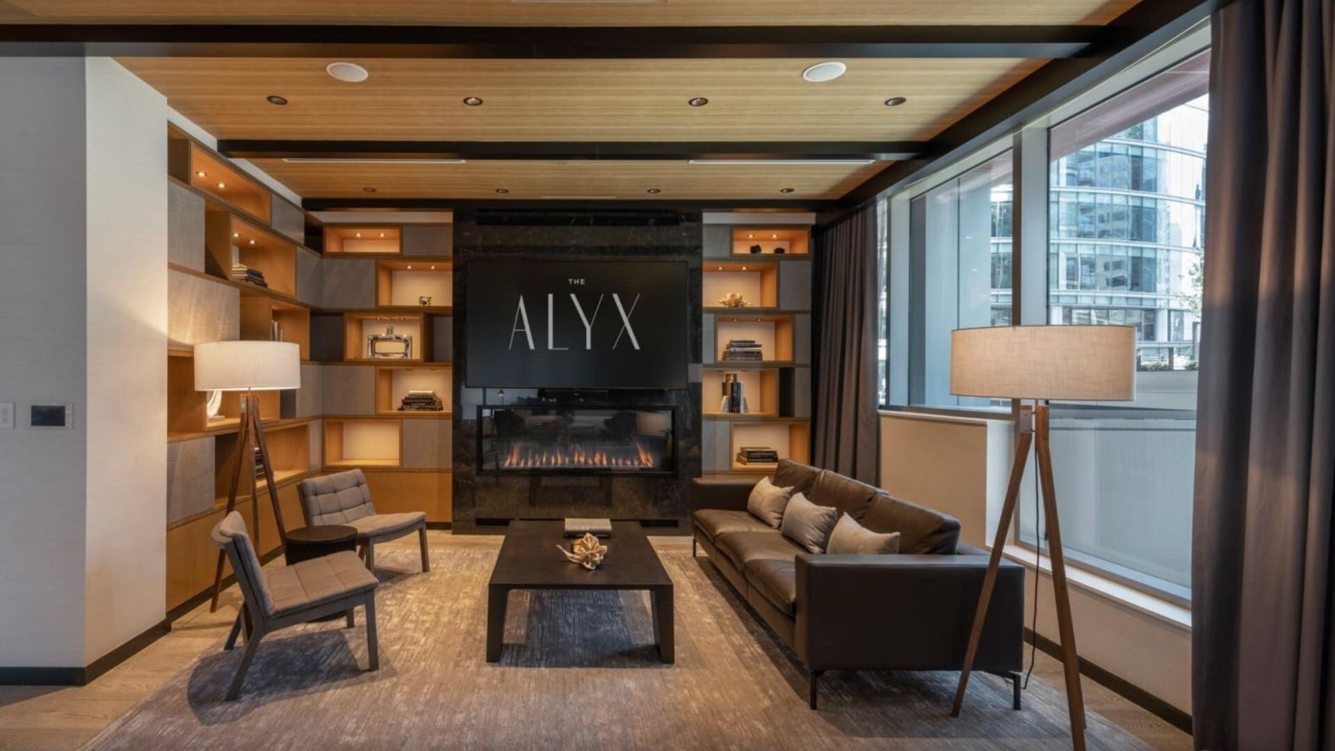 A modern living room with a fireplace, comfortable seating, and bookshelves.