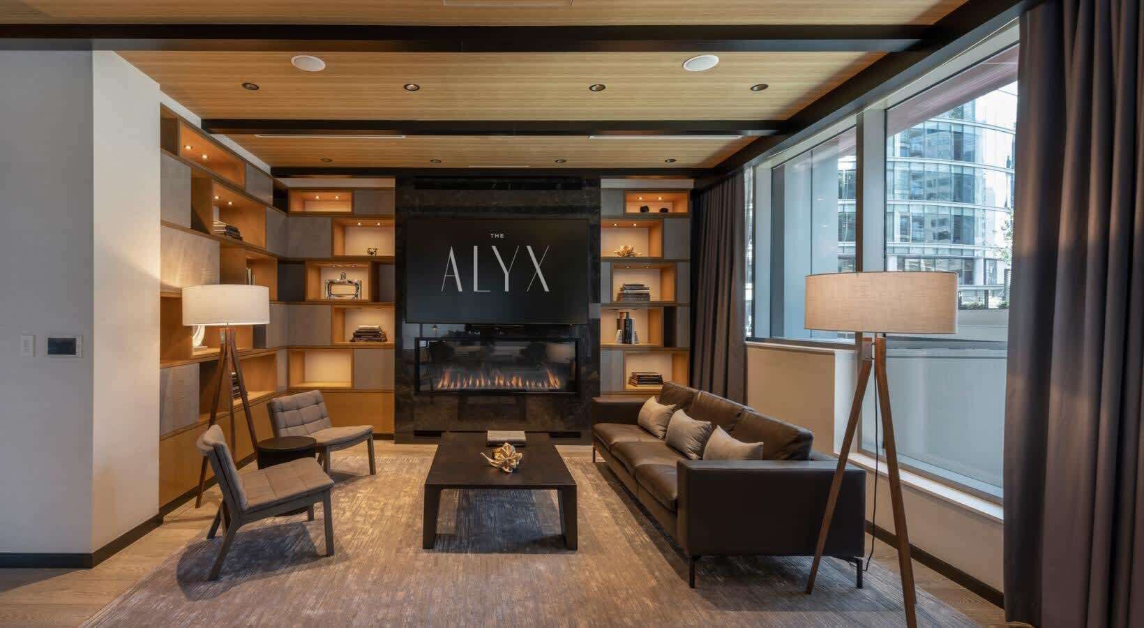 A modern living room with a fireplace, a large TV, and a bookshelf.