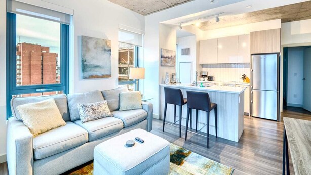 A modern apartment with a living room, kitchen, and dining area. - Modern Apt In Kendall Square with Gym (Cambridge)
