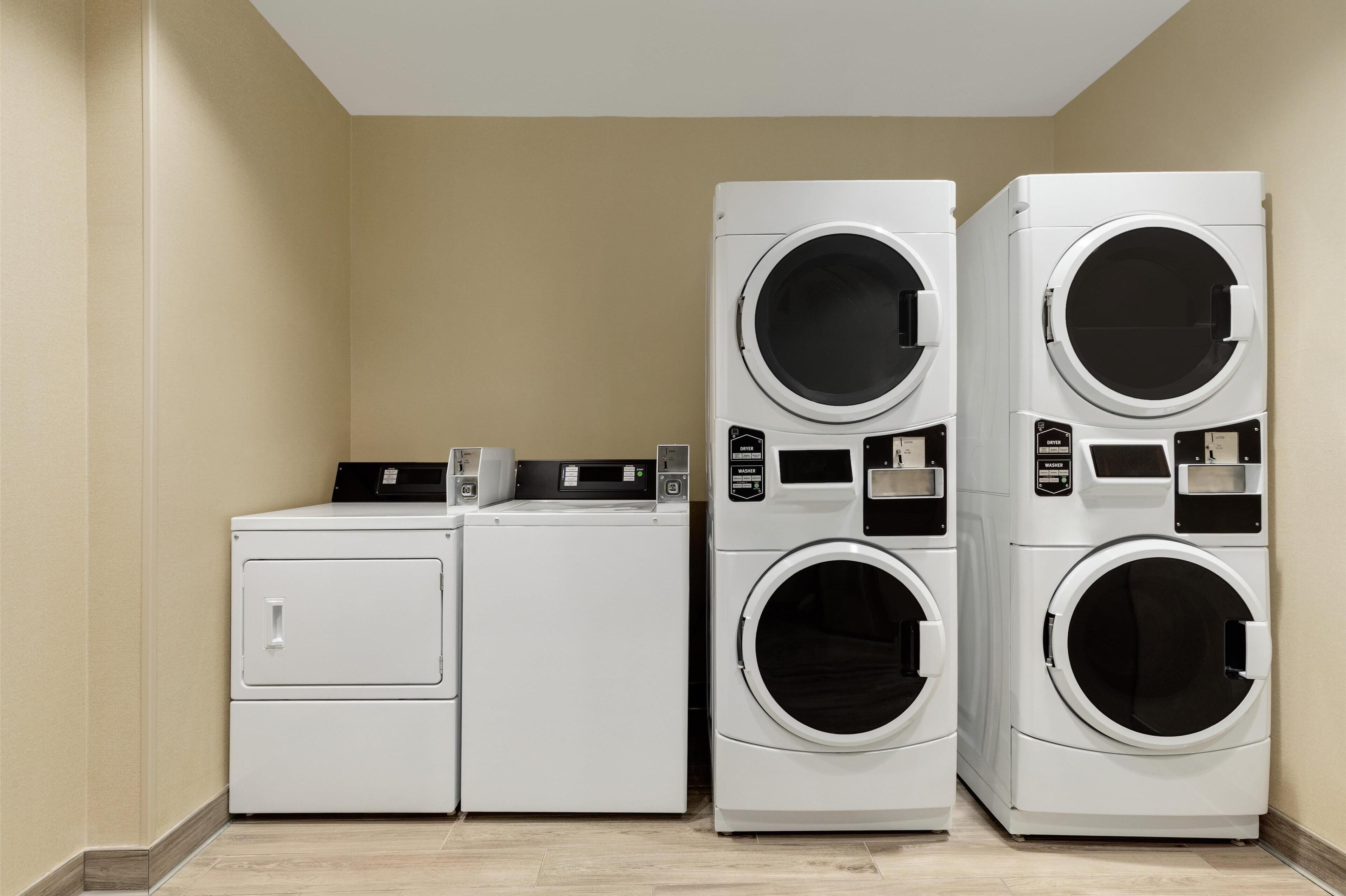A laundry room with two dryers and a washing machine.
