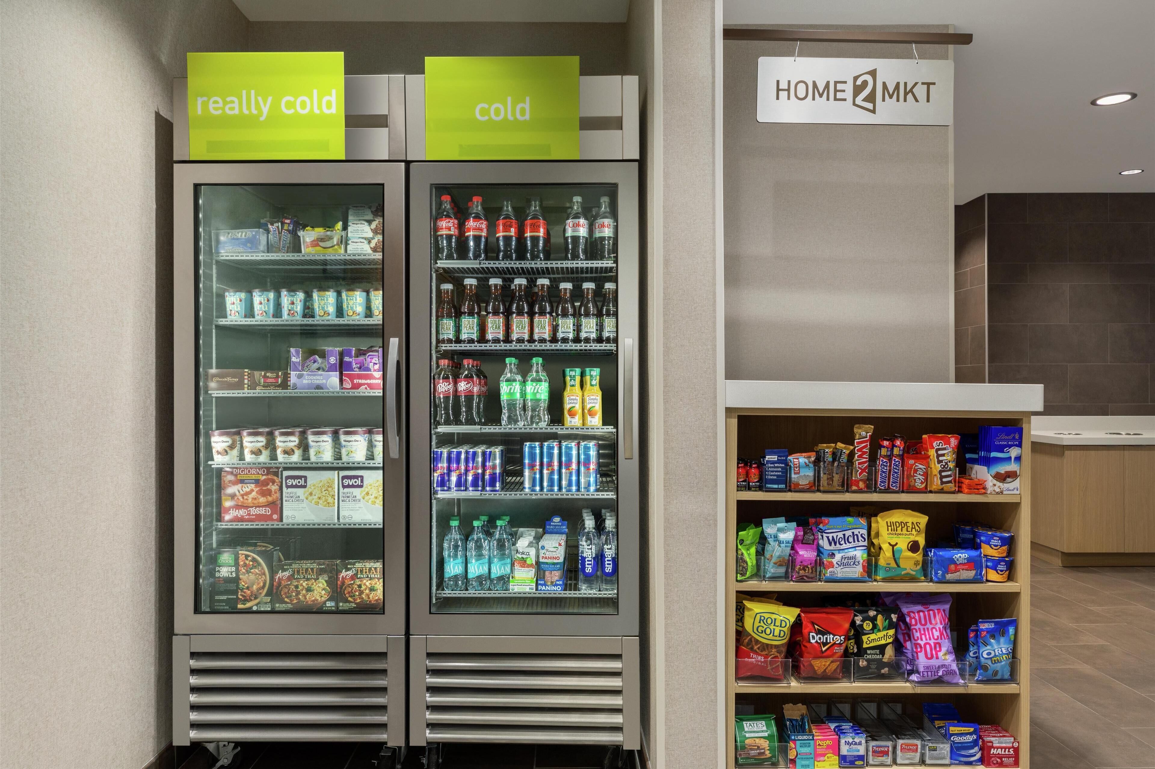Dos dispensadores de bebidas refrigeradas, uno etiquetado 'muy frío' y otro 'frío', con diversas bebidas y aperitivos.
