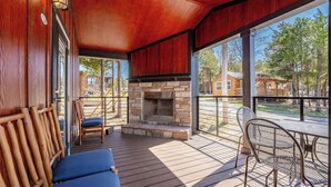 A covered outdoor area with a stone fireplace, wooden benches, and a metal table. - Indian Point Cabin near SDC Table Rock Lake & Branson (Branson)