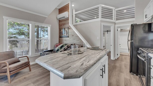 A modern kitchen with a central island, built-in appliances, and a staircase leading to an upper level. - Indian Point Cabin near SDC Table Rock Lake & Branson (Branson)