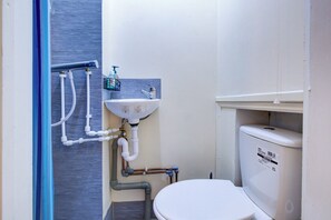 A small bathroom with a toilet, sink, and shower. - Single Ensuite in SW2 Close to Central London (London)