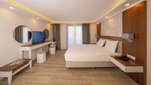 A modern hotel room with a large bed, a TV, a desk, and a small seating area. - MARVELOUS SARIGERME (Sarigerme)