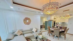 A modern living room with a sofa, coffee table, and chandelier. - Landmark 81 Residences Luxury (Ho Chi Minh City)