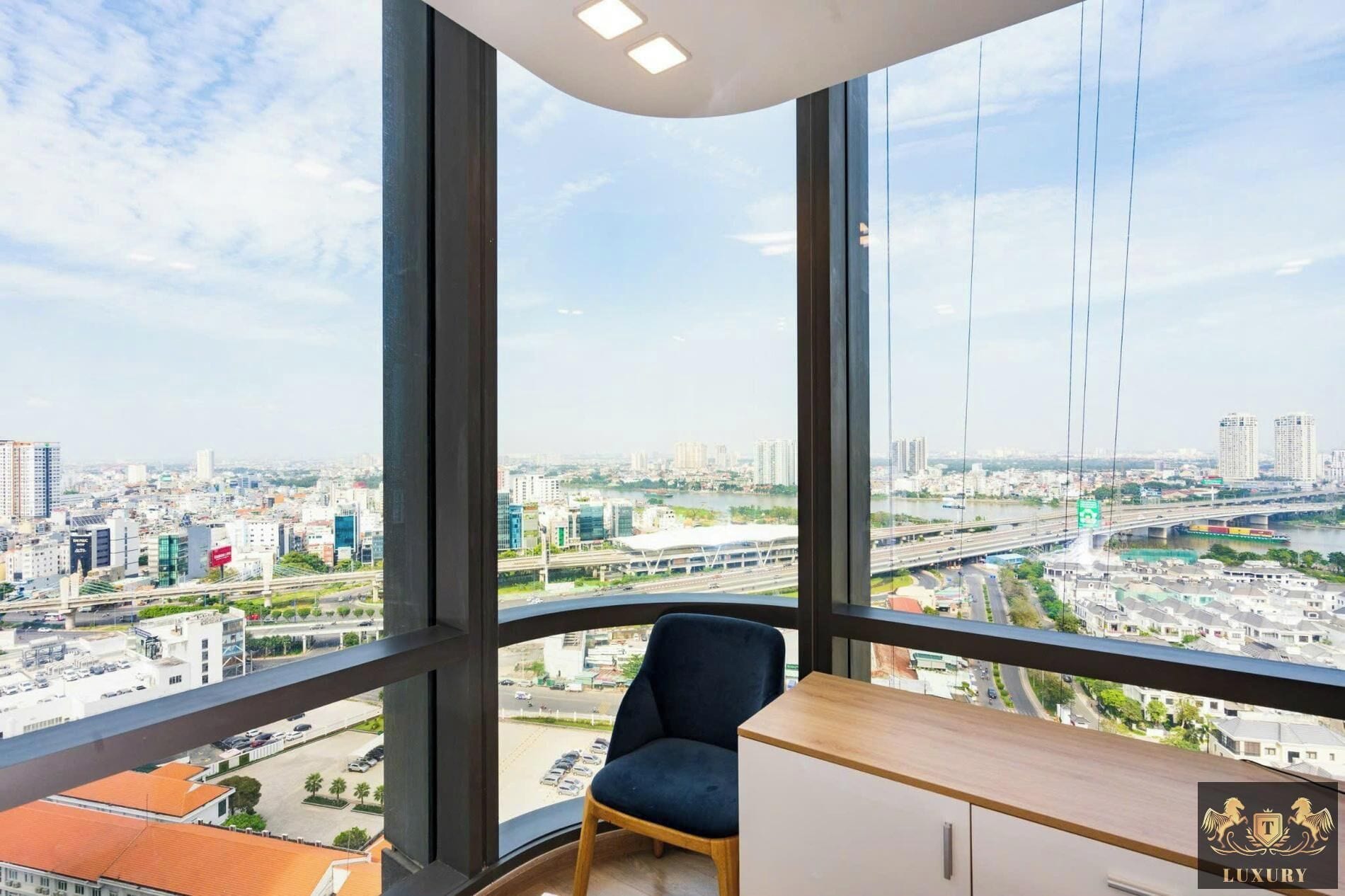 Espacio de oficinas en un rascacielos con un amplio ventanal que ofrece vistas a la ciudad, un escritorio y una silla.