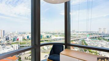 Espacio de oficinas en un rascacielos con un amplio ventanal que ofrece vistas a la ciudad, un escritorio y una silla.