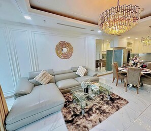 A modern living room with a sofa, coffee table, and chandelier. - Landmark 81 Residences Luxury (Ho Chi Minh City)