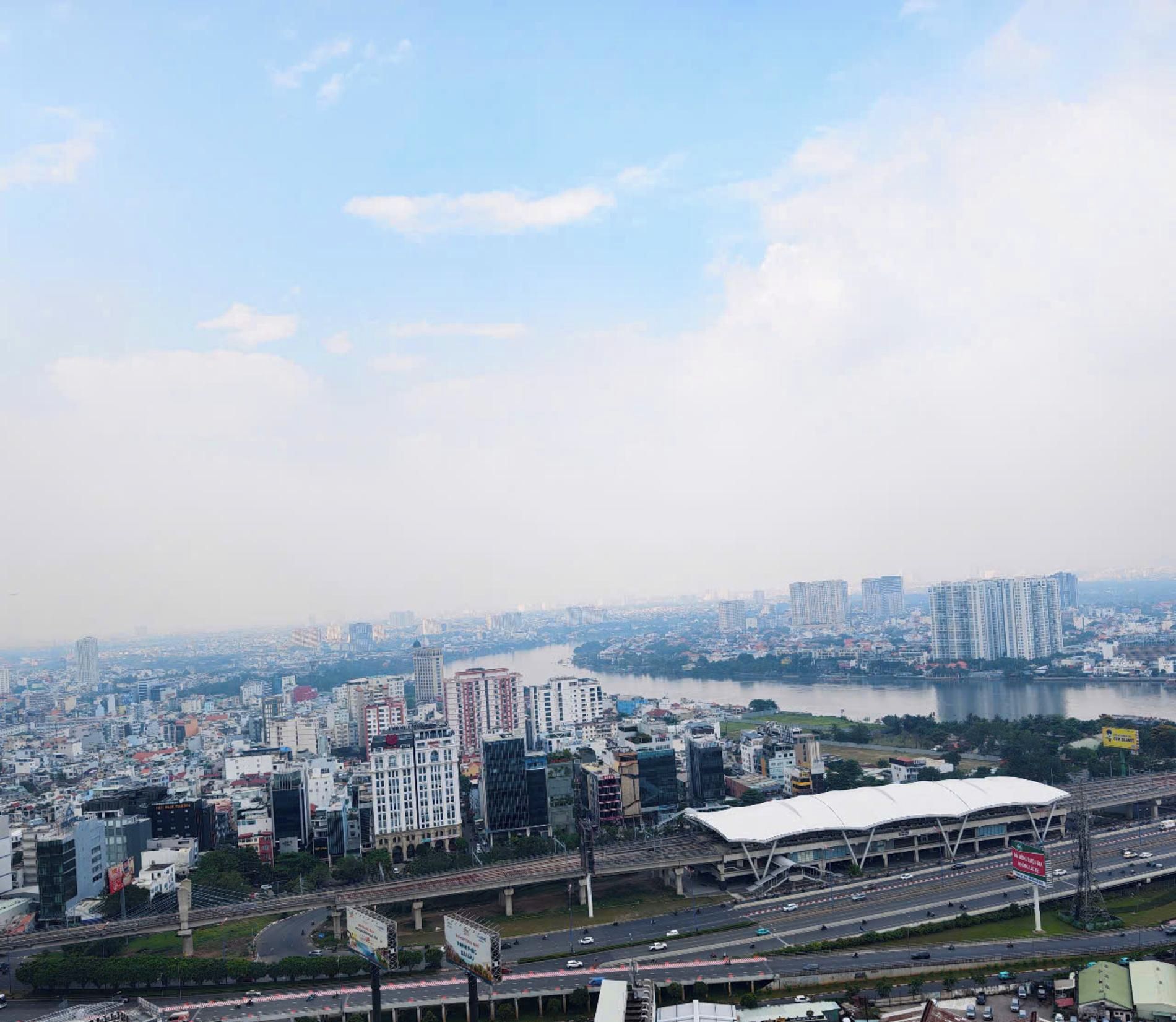 A cityscape with a river, high-rise buildings, and a large stadium.