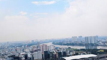 A cityscape with a river, high-rise buildings, and a large stadium.