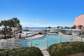 Relax by the oceanfront pool surrounded by lounge chairs and umbrellas.