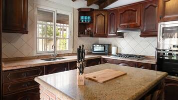 Een koelkast, een magnetron, kookgerei, borden en bestek