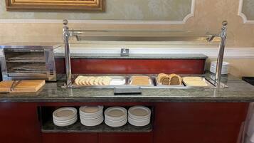 Una mesa de buffet con diversos alimentos y utensilios.