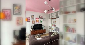 A living room with a television, sofa, and bookshelf.
