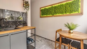 A modern kitchen with a marble backsplash, a wooden countertop, and a built-in green wall garden. - RentPlanet - Apartament Kościuszki (Wroclaw)