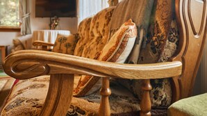 Ein Holzstuhl mit geschwungener Rückenlehne und Sitzkissen mit Blumenmuster.