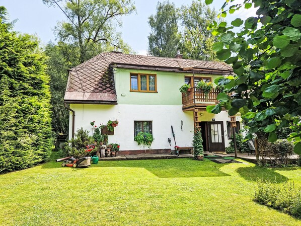 Enjoy the serene atmosphere of this charming two-story house with a balcony and beautifully manicured garden.