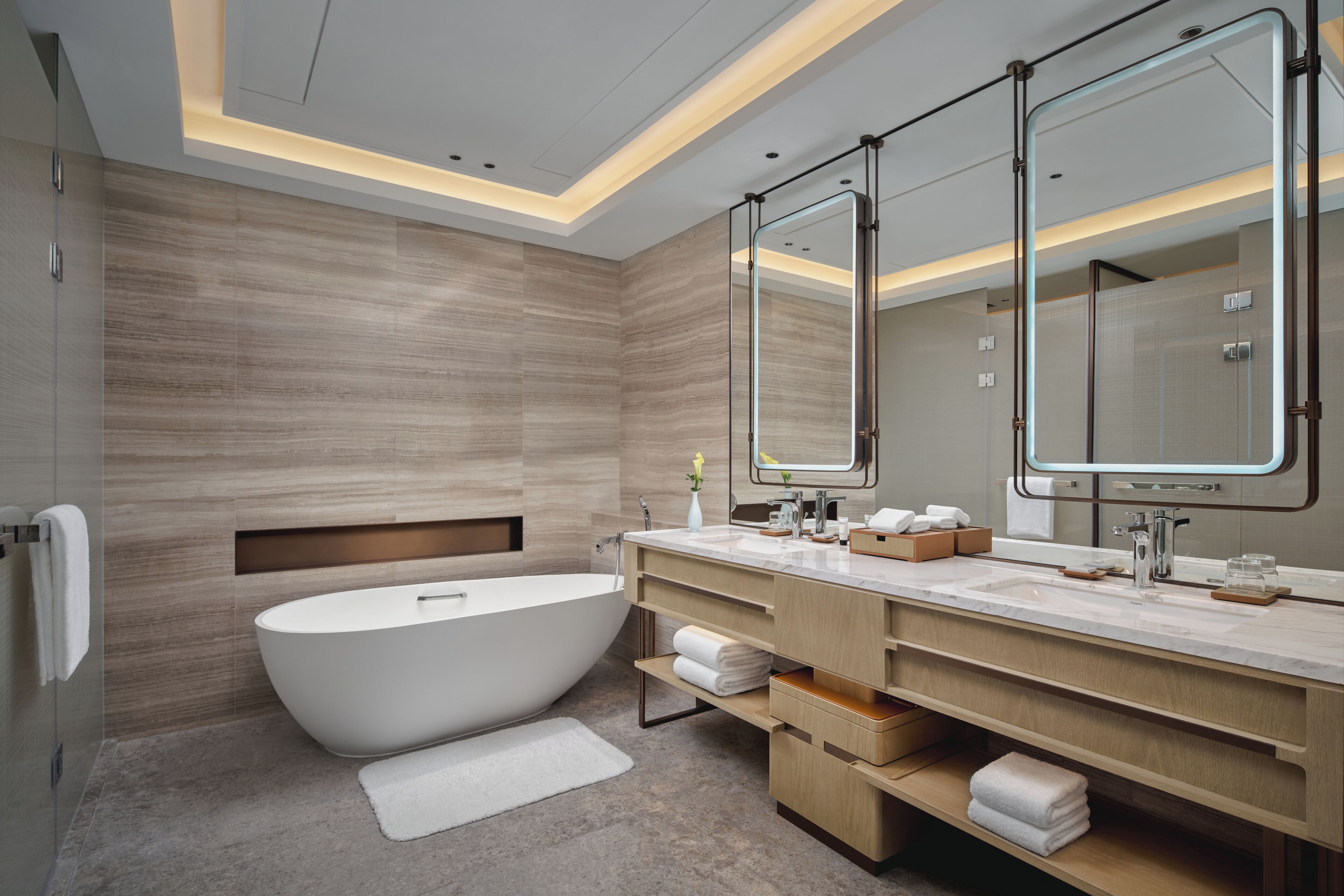 A modern bathroom with a freestanding bathtub, a large mirror, and a vanity with a countertop.