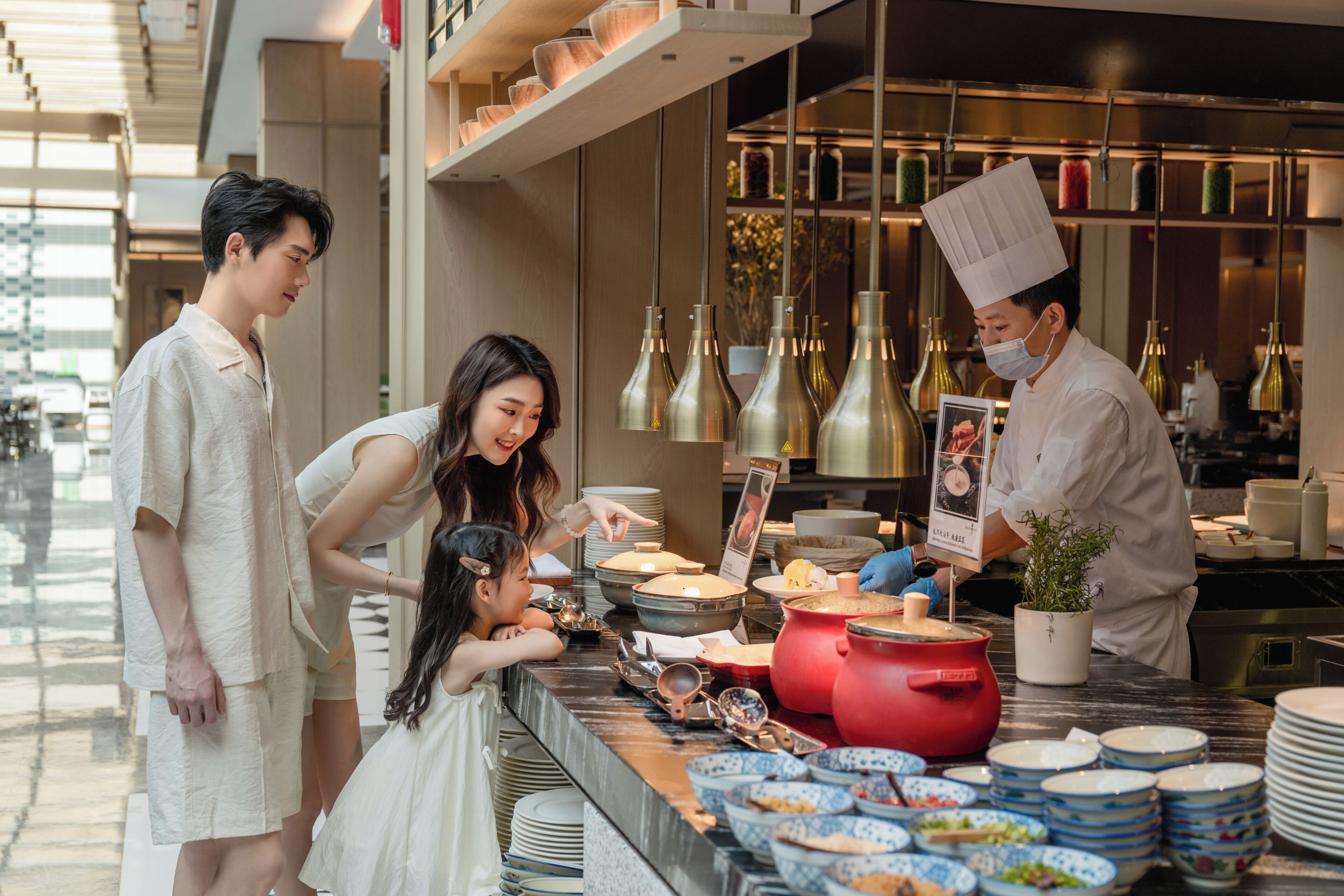Un buffet où l’on voit un chef, une femme et deux enfants.