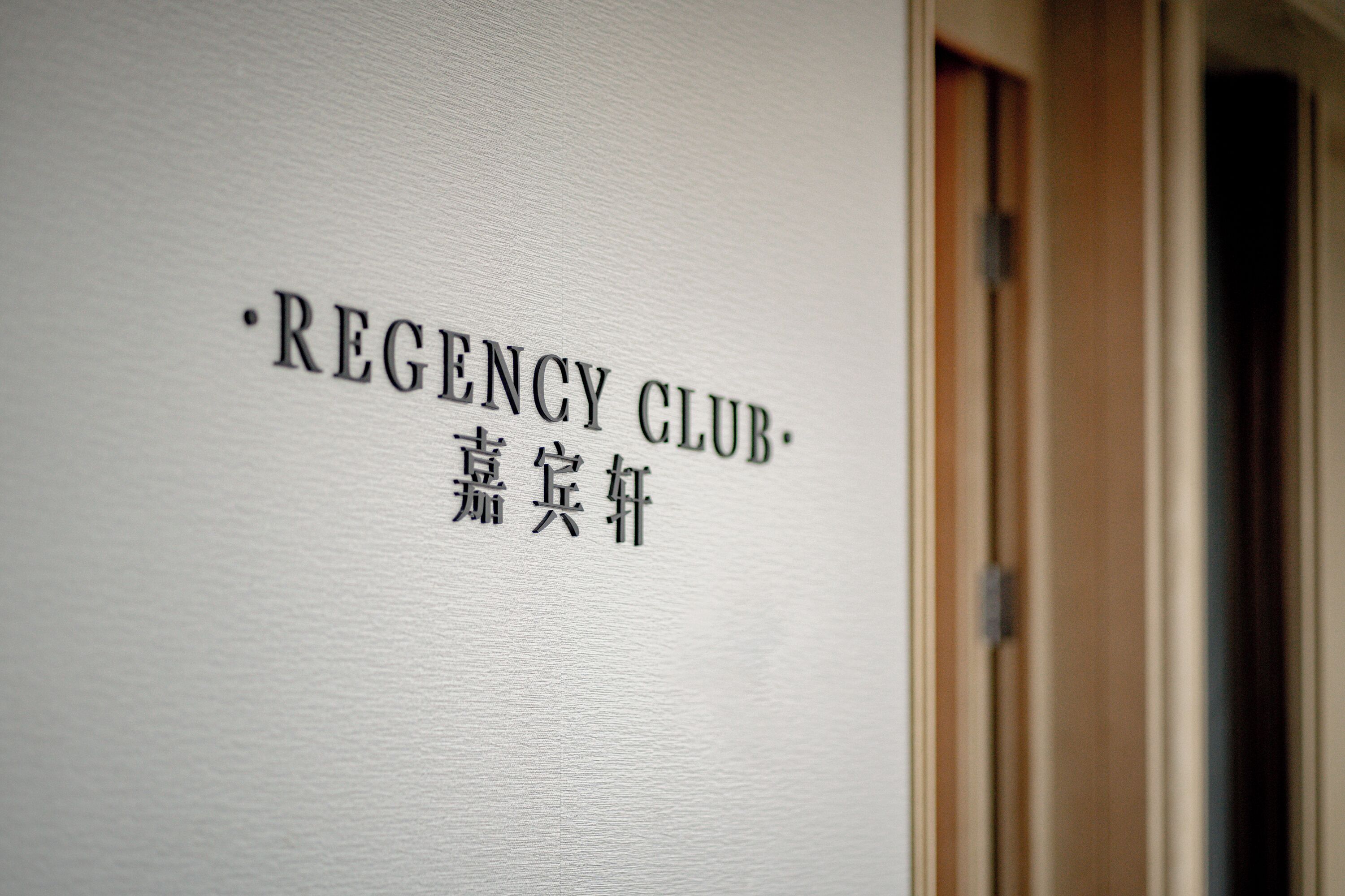 A wall with the text 'REGENCY CLUB' and some non-English characters.