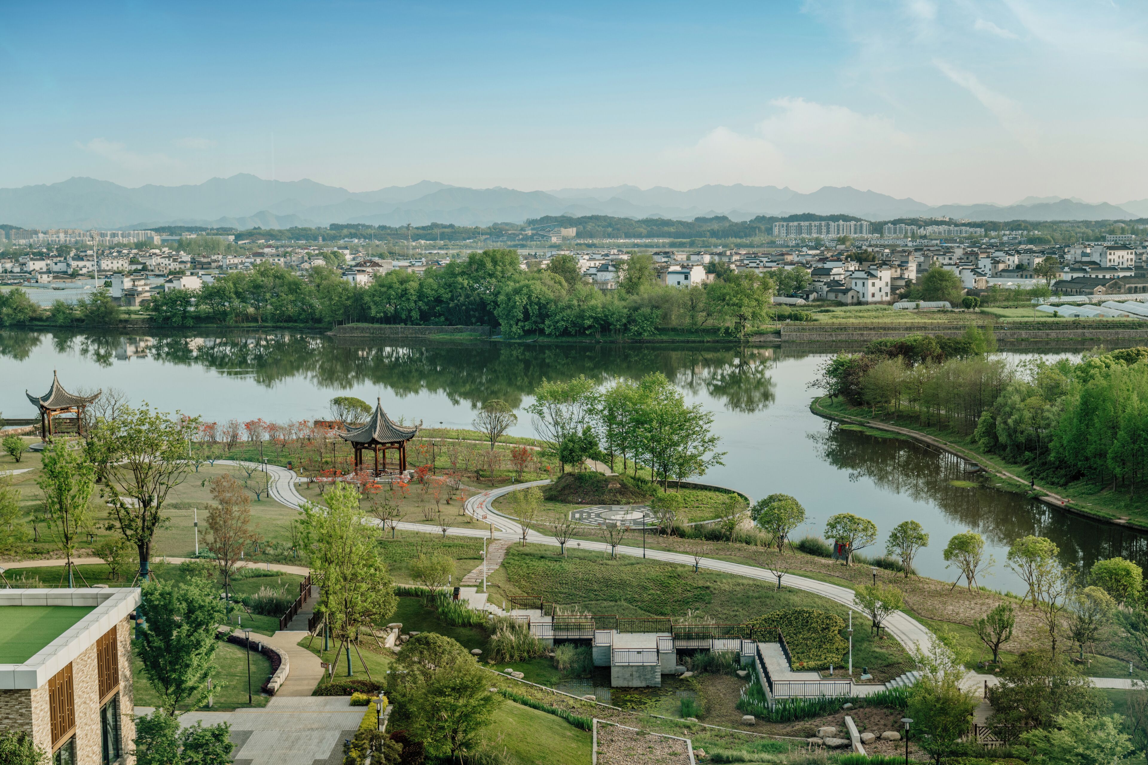 A park with a pavilion, pathways, and a lake.