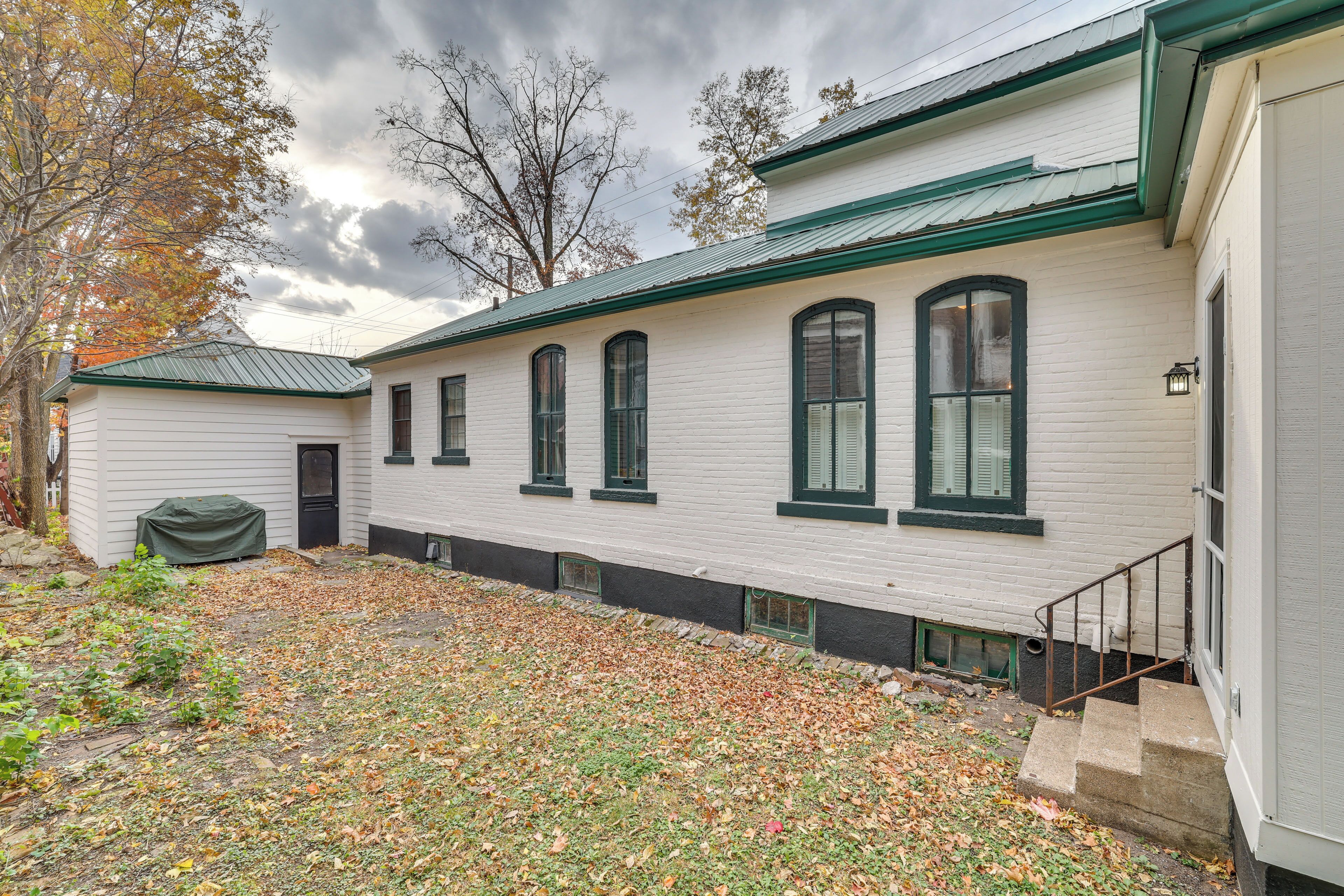 A two-story white building with green trim and multiple windows.