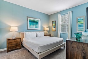 - Cozy bedroom with a modern aesthetic, featuring a plush king bed and vibrant artwork - Ample natural light fills the room through large windows - Equipped with stylish furniture, including bedside tables with lamps and smart TV for relaxation - Disney near Resort 9BR Home Oasis w/ Pool (Kissimmee)