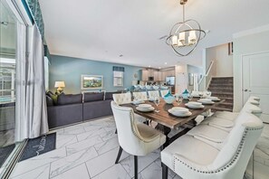 - Open-plan dining and living area is perfect for socializing, featuring a modern dining table set for eight - Stylish decor complemented by contemporary furnishings and decorative accents - Designed to be both functional and aesthetically pleasing - Disney near Resort 9BR Home Oasis w/ Pool (Kissimmee)
