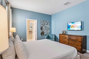 A bedroom with a bed, a dresser, a television, and a wall art piece. - Disney near Resort 9BR Home Oasis w/ Pool (Kissimmee)