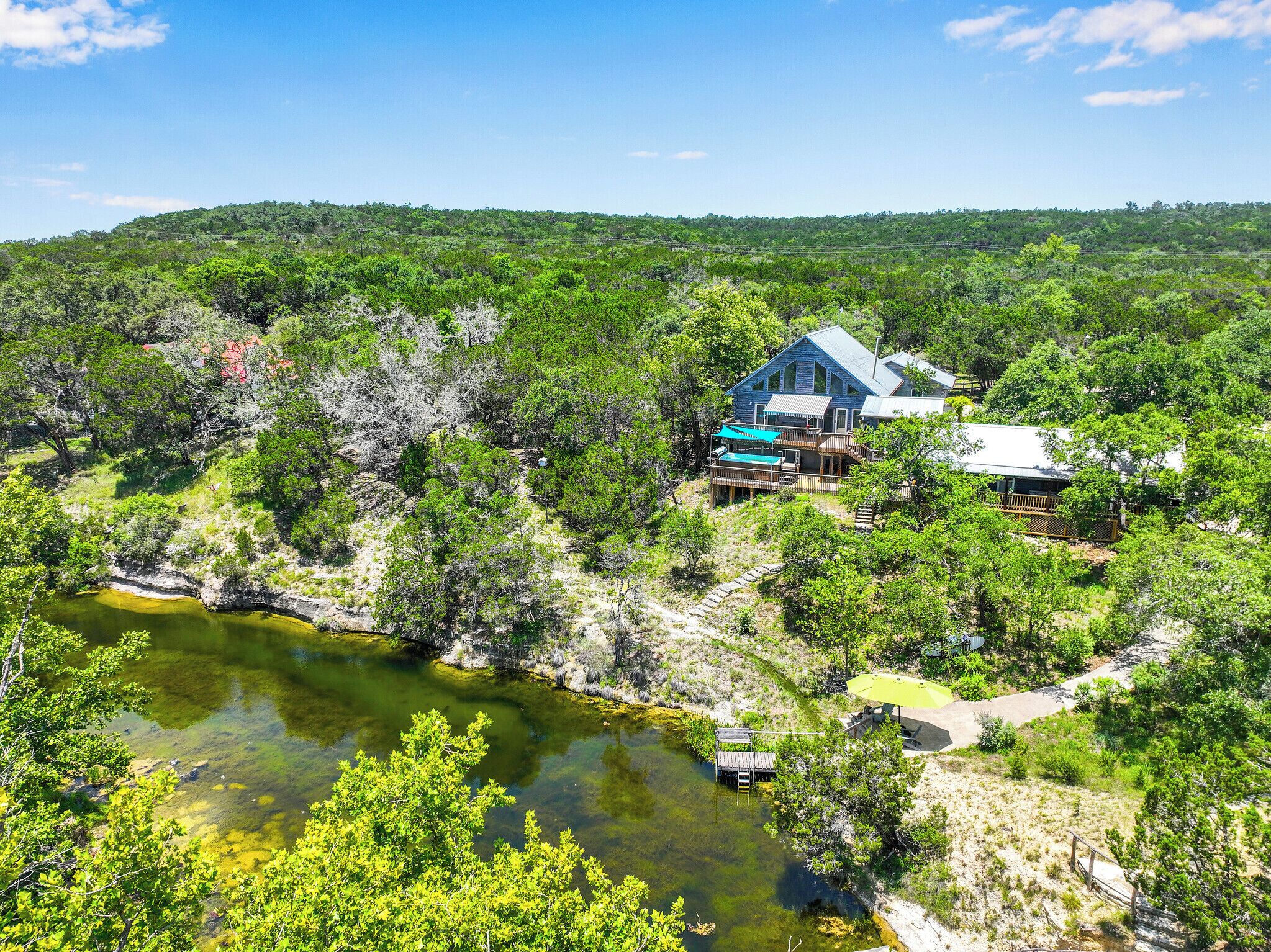 Uma casa rodeada por vegetação densa e um rio.