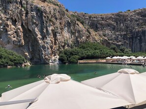 Eine Küstenlandschaft mit Klippen, einem Swimmingpool und Strandliegen.