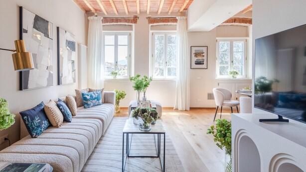 A modern living room with a sofa, coffee table, and decorative plants. - Letters From Lucca in Lucca (Lucca)