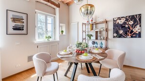 A dining area with a wooden table set for four, surrounded by chairs, with a brick ceiling and pendant lights above. - Letters From Lucca in Lucca (Lucca)