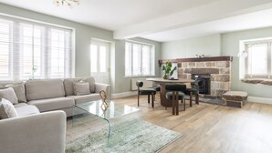 Ein geräumiges Wohnzimmer mit einer Couch, einem Glastisch und einem Kamin.