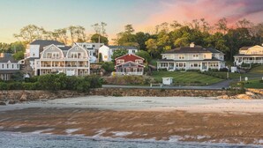 Une zone résidentielle côtière avec des maisons, une plage et un mur de pierre.
