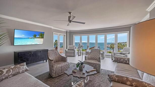 A spacious living room with a large TV, comfortable seating, and a view of the ocean. - An Ocean Serenity at the Truman Annex in Key West (Key West)