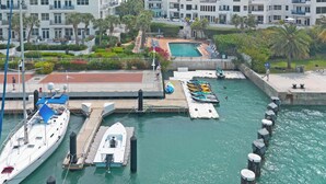 A marina with boats docked, a swimming pool, and a building with balconies. - An Ocean Serenity at the Truman Annex in Key West (Key West)